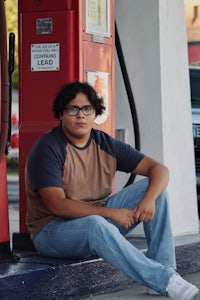 a man sitting on the steps of a gas station
