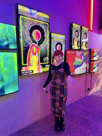 a woman standing in front of a display of colorful tvs