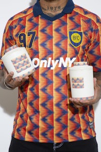 a man holding a cup and a soccer jersey