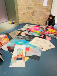 a group of people working on a large piece of art