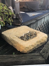 a stone fountain sitting on top of a deck