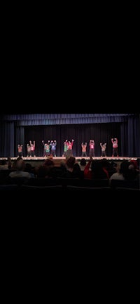 a group of people on stage performing a dance