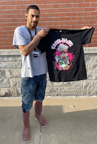 a man holding up a t - shirt with a cartoon on it