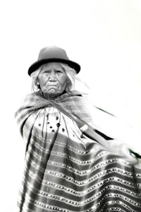 a black and white photo of an old woman in a blanket