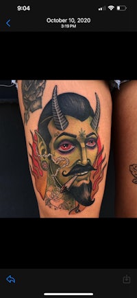 a tattoo of a devil on a woman's thigh