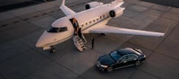 a private jet is parked next to a car