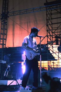 a man playing a guitar at a concert