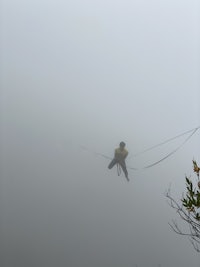 a man flying a kite in the fog