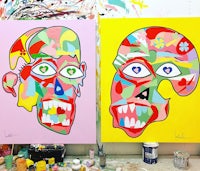 two colorful paintings on a table in a studio