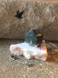 a small house on a rock with a bird on it