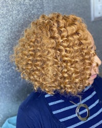 a woman with curly hair in a salon