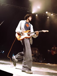 a man playing an electric guitar on a stage