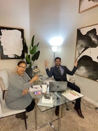 two people sitting at a desk in a home office