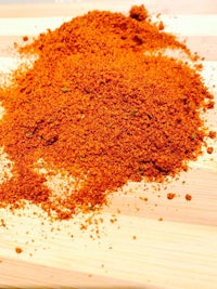 a pile of red chili powder on a cutting board