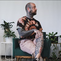 a man sitting in a chair with tattoos