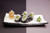 japanese sushi on a white plate with a black background