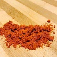 a pile of red powder on a wooden table