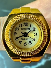 a gold ring with a watch on it