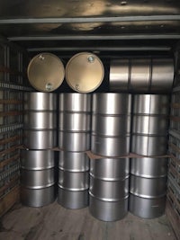 stainless steel barrels in the back of a truck