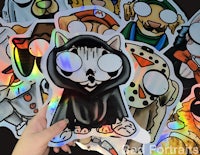 a person holding a bunch of holographic stickers