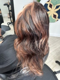 a woman's hair in a salon with long wavy hair