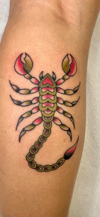 a scorpion tattoo on a woman's thigh
