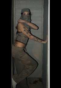 a woman with tattoos standing in a doorway