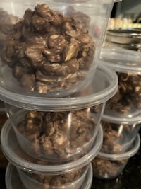 chocolate covered peanuts in plastic containers on a counter