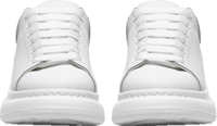 a pair of white sneakers on a black background