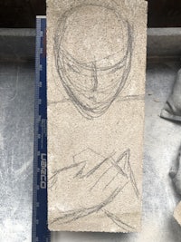 a drawing of a head on a piece of concrete