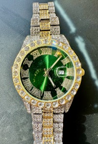 a gold and green watch with diamonds on it