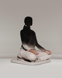 a silhouette of a woman meditating on a platform