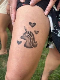 a woman with a tattoo of a unicorn on her thigh