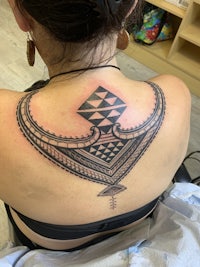 a woman with a tribal tattoo on her back