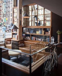 a living room with a bicycle and bookshelves