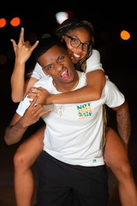 a couple posing for a photo in a white t - shirt