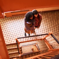 two women standing on a staircase