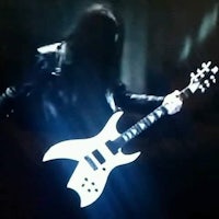 a man with long hair is playing an electric guitar