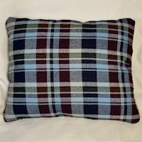 a plaid pillow on a white surface