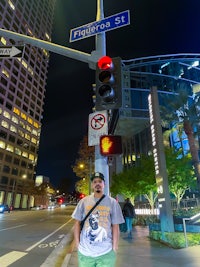 a man standing next to a traffic light on a city street