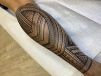 a man with a tribal tattoo on his forearm