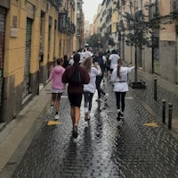 a group of people running down a rainy street