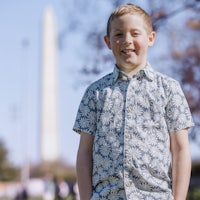a young boy standing in front of the washington monument