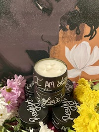 a black candle surrounded by flowers and flowers