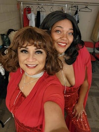 two women in red dresses posing for a photo
