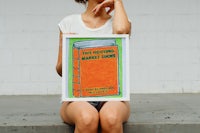 a woman holding up a poster with a book on it