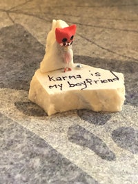 a small figurine with a message on it sitting on the floor