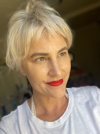 a woman wearing a white t - shirt and red lipstick
