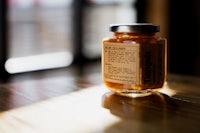 a jar of honey sitting on a wooden table