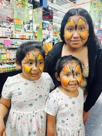 two girls with butterfly face paint in a grocery store